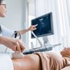 Doctor pointing at computer screen during prenatal ultrasound
