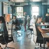 Young professionals work in an open office setting.