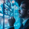 Man looking at computer screen with charts and graphs