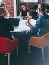 Supervisor briefing and leading a meeting with his colleagues in a modern workplace.