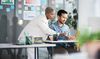 Business people discussing work on laptop in an office setting