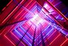  A glass elevator shaft with colourful lighting at every level.