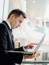 Businessperson points at the screen of a laptop.