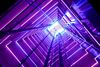  A glass elevator shaft with purple lighting at every level.
