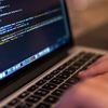Close-up of hands coding on a laptop.