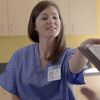 Medical professional reaches for forms from a patient.