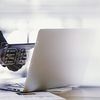 Person in suit works on a laptop.