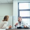 Doctor and staffer having a discussion in a hospital office