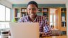 A person smiles while participating in a free, virtual cloud consultation on a laptop at home.